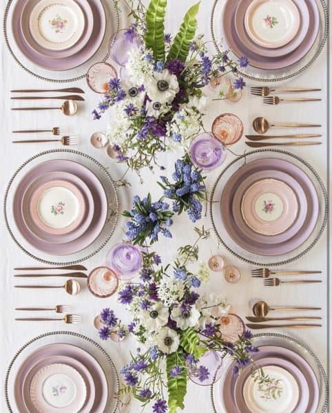 A beautifully arranged spring table setting featuring pastel-colored plates, floral centerpieces, and elegant cutlery, creating a fresh and inviting dining atmosphere.
