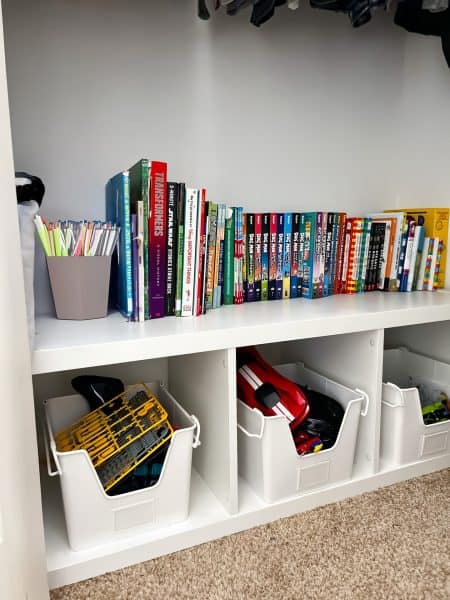 an Ikea bookcase turned on it's side for toy storage and books organized on top