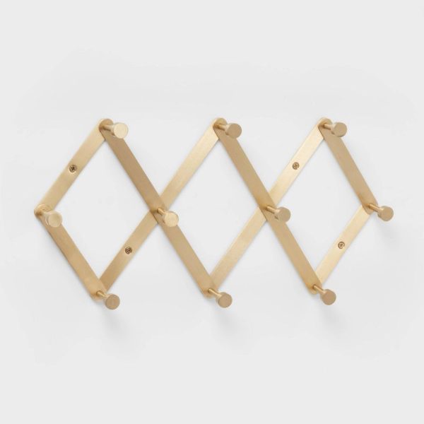 Gold-colored wall-mounted coat rack with a zigzag design and multiple hooks.