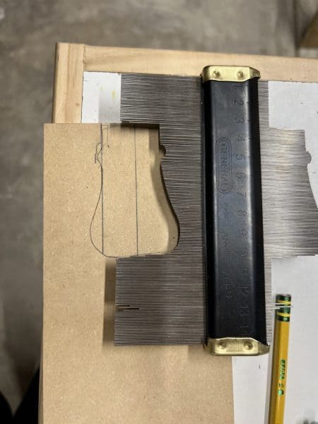 Contour gauge used to trace the profile of the existing banister, helping to wrap the MDF completely around the newel post for a custom fit.