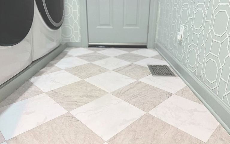 Peel-and-stick tile flooring installed over original tile in a narrow laundry room with a checkerboard pattern.