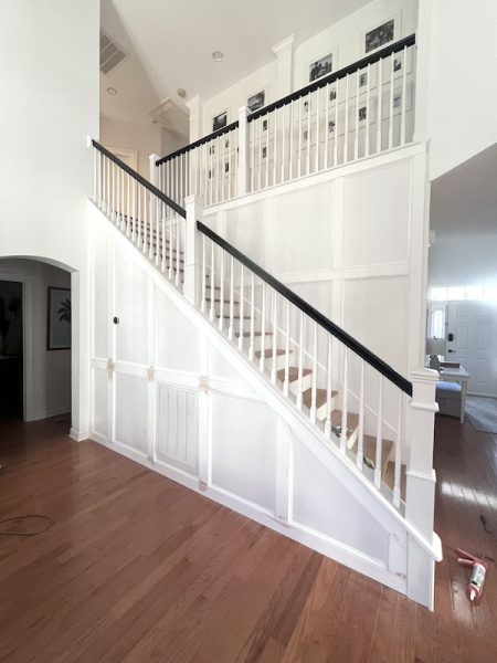 Work in progress during the staircase renovation, with horizontal and vertical molding pieces being installed to form the grid design.