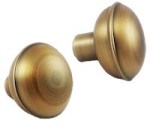 Close-up of two vintage-style brass door knobs with a smooth finish.