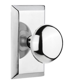 Close-up of a polished chrome round door knob mounted on a square plate, showcasing a modern and sleek design.