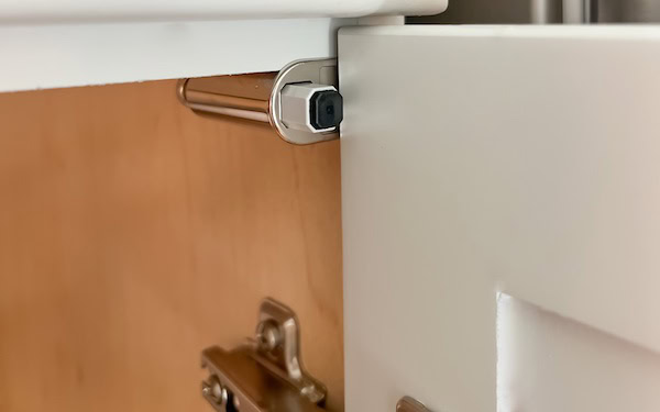 Close-up of a soft close damper installed in a cabinet door, showcasing the mechanism and its positioning relative to the door and cabinet frame.