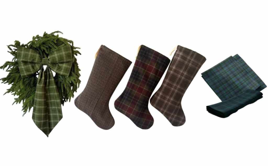A festive green wreath adorned with a plaid bow, accompanied by three patterned stockings and two pieces of plaid fabric.