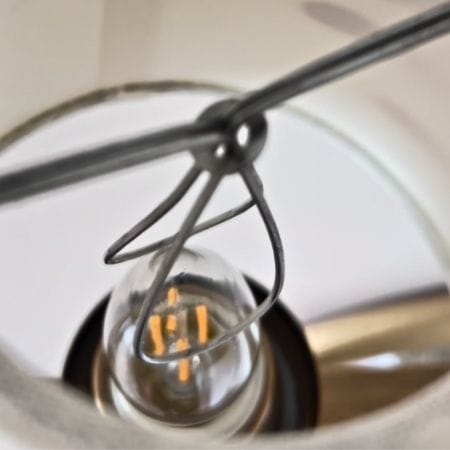 Close-up of a vintage light bulb in a socket, installing a clip on lamp shade