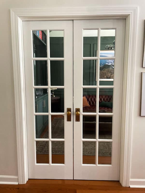 White interior French doors in entryway hallway that lead into a home office