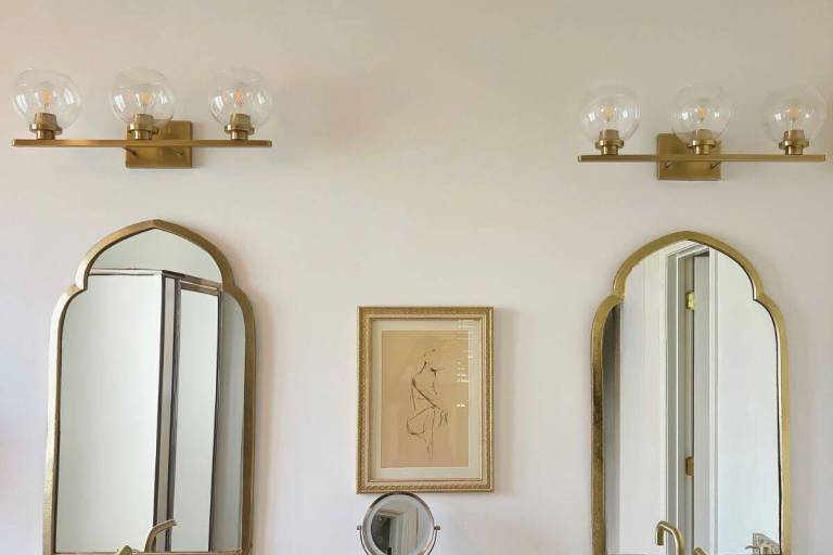 Bathroom vanity lights with original glass globes before the DIY lighting update.