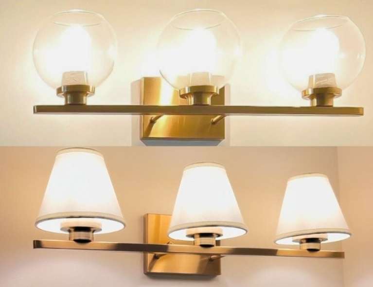 Side-by-side before and after of a DIY bathroom vanity lighting update showing the switch from glass shades to white linen clip-on lamp shades.