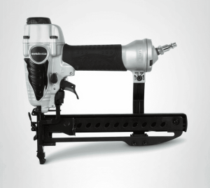 A metal air nailer with a black and silver design, featuring a safety trigger and a magazine for loading nails.