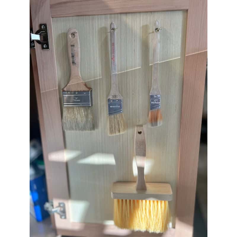 storing paintbrushes on hooks inside cabinet