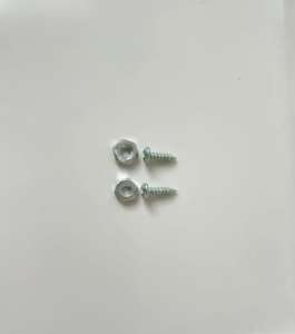 A close-up image of two metal screws and two nuts placed on a white surface.