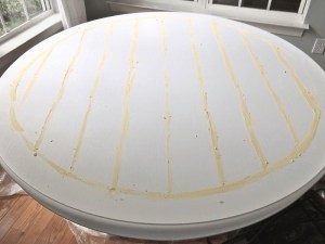 Wooden dining table with crumb-trapping grooves, ready for refinishing.