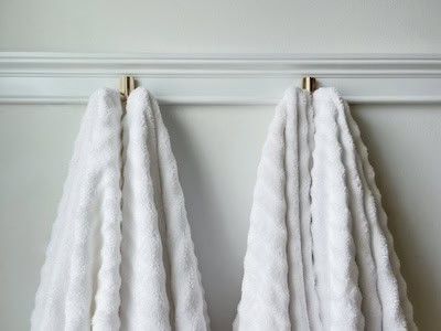four large white towels hanging on a towel rack