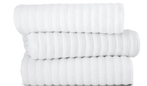Three neatly rolled white towels stacked on top of each other.