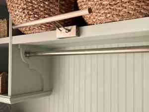 Laundry room hanging rod under shelf with baskets and built-in storage