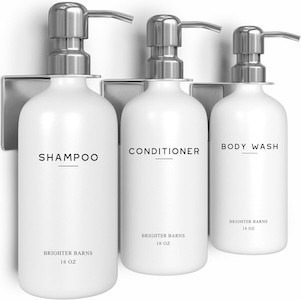 Set of three white shower bottles labeled shampoo, conditioner, and body wash.